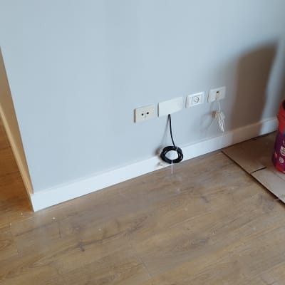 רצפת פרקט עם דליי צבע ליד קיר