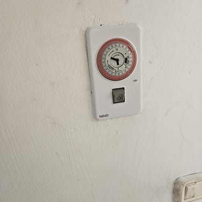 שעון טיימר לדוד שמש על קיר לבן