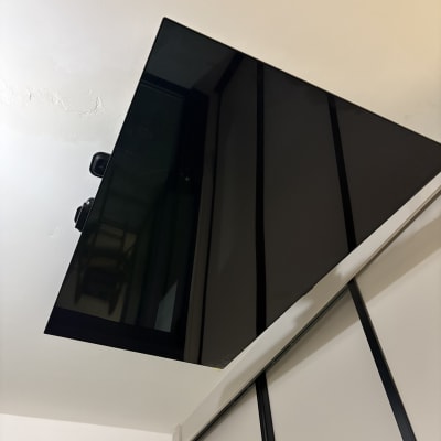 מסך טלוויזיה מותקן על קיר עם זרוע מתכווננת