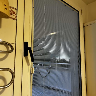 תריסים ונציאניים לבנים על חלון זכוכית