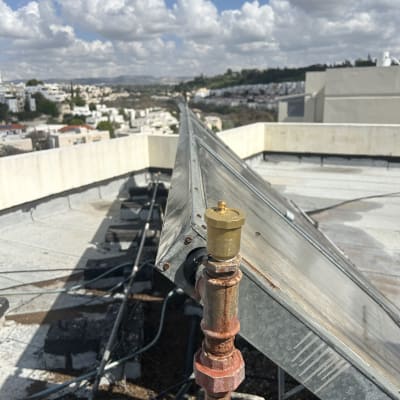 מערכת סולארית על גג עם נוף עירוני ברקע