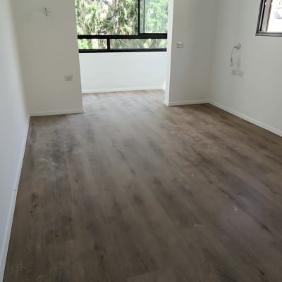 רצפת פרקט עץ כהה בחדר ריק עם חלון גדול