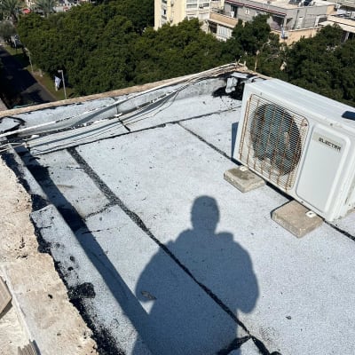 גג עם חומרי איטום, צל של אדם, מזגן