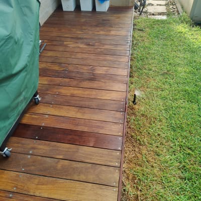 דק עץ ליד דשא ירוק עם פחי אשפה