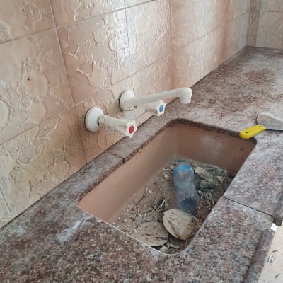 כיור מלוכלך עם בקבוק פלסטיק ופסולת