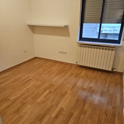 חדר ריק עם רצפת עץ נקייה וחלון