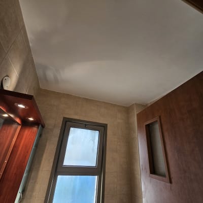 תקרה צבועה בחדר עם חלון ודלת עץ