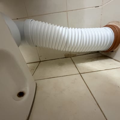 צינור לבן מחובר לקיר בחדר אמבטיה