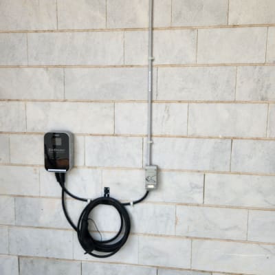 מטען חשמלי מותקן על קיר עם כבל טעינה