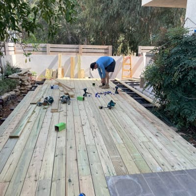 בניית דק עץ עם כלים ועובד בגינה