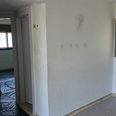 קיר צבוע עם סימני תיקון, יריעות פלסטיק על הרצפה