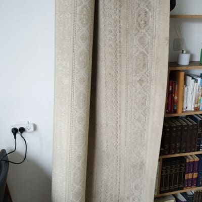 שני שטיחים מגולגלים עומדים על הקיר