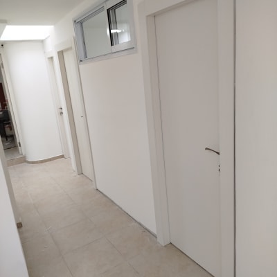 מסדרון עם דלתות לבנות ודלת עם חלון עליון