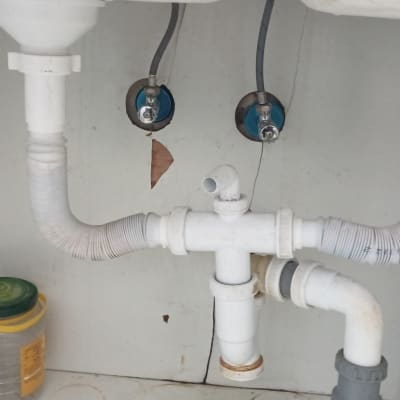 צנרת פלסטיק מתחת לכיור עם חיבורים וברזים