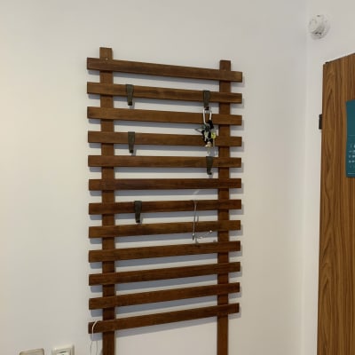 מתלה עץ עם ווים לתליית חפצים על קיר לבן