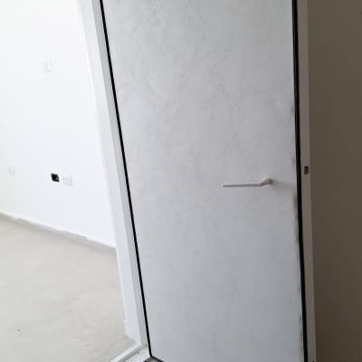 דלת מצופה בצבע לבן עם ידית לבנה