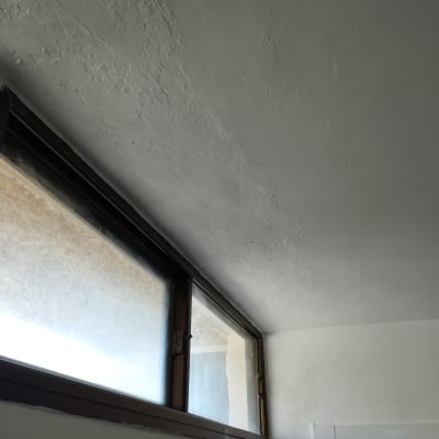 קיר ותקרה צבועים בלבן עם חלון גדול