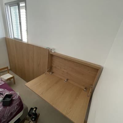 שולחן עץ מתקפל עם צירים על קיר לבן