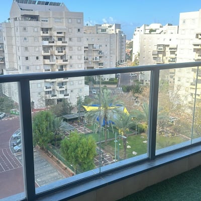 מעקה זכוכית במרפסת עם נוף לעיר