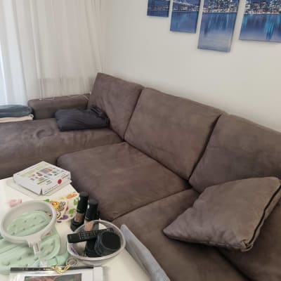 ספה חומה עם כריות ושולחן עם חפצים שונים