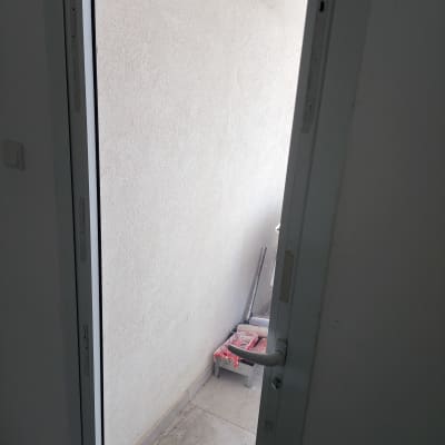 דלת זכוכית עם ידית פתוחה ומרפסת קטנה