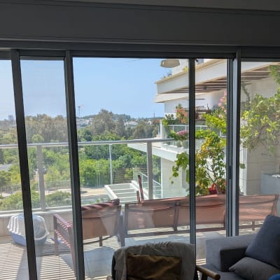 מרפסת עם צמחים ותריסים שקופים