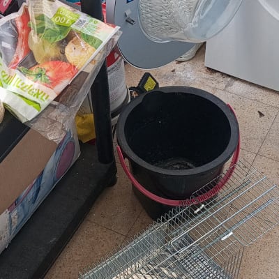 מלכודת מתכת על רצפה ליד דלי שחור