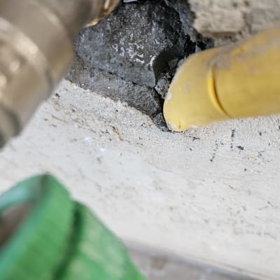 צינור צהוב וירוק ליד קיר עם סדק