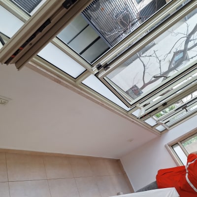 אישה מצלמת קיר לבן עם חלונות פתוחים