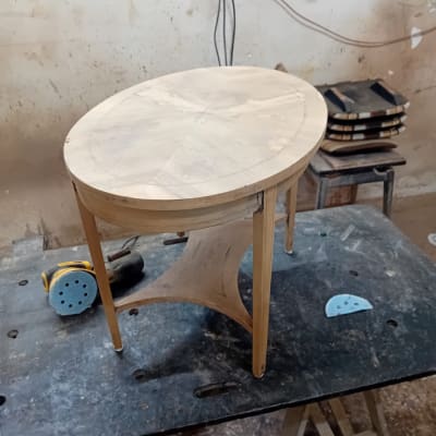 שולחן עגול מעץ על שולחן עבודה עם מלטשת