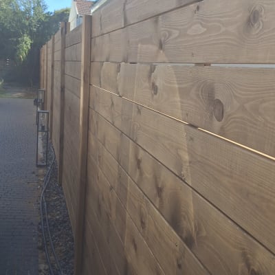 גדר עץ חומה עם צינורות השקיה לאורך השביל