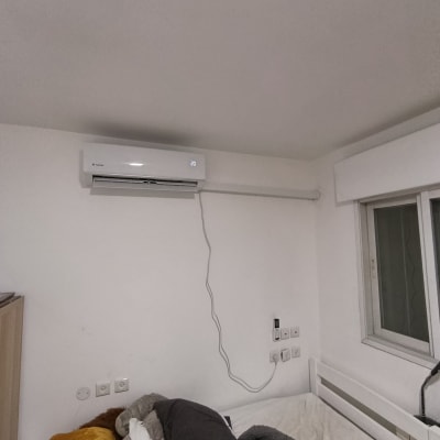 מזגן מותקן על קיר בחדר שינה עם מיטה
