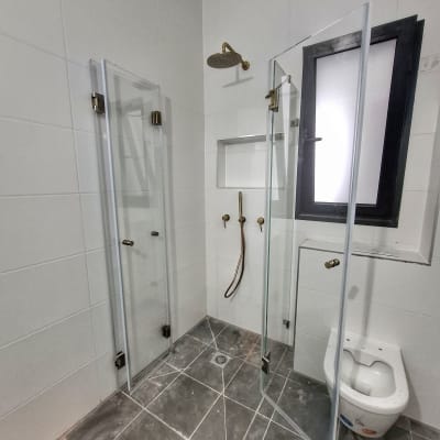 מקלחון עם דלתות זכוכית וברז זהב