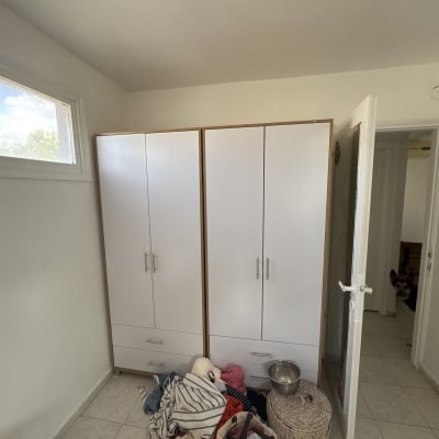 ארון בגדים לבן עם ידיות מתכת בחדר