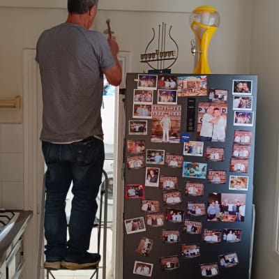 אדם על סולם מתקין גוף תאורה בתקרה