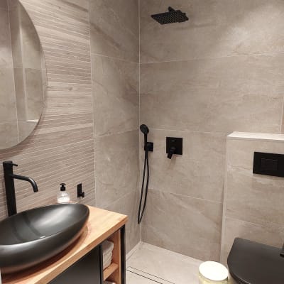 חדר רחצה מודרני עם כיור שחור וברז תואם