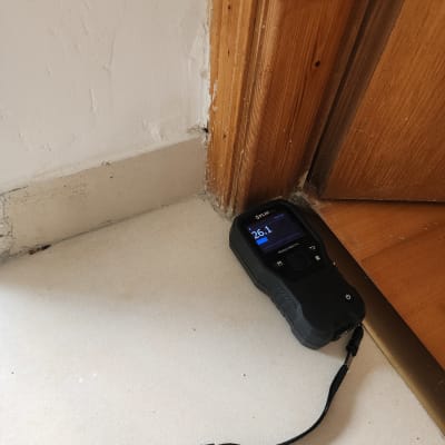 מד לחות דיגיטלי ליד דלת עץ על רצפה