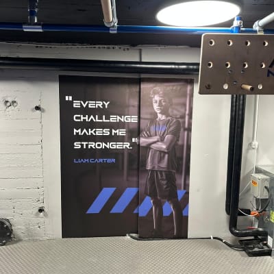 פוסטר עם דמות וכיתוב על קיר במכון כושר