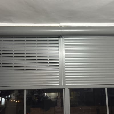 תריסי אלומיניום אפורים מותקנים על חלון