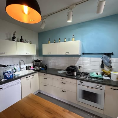 קיר כחול במטבח עם ארונות לבנים