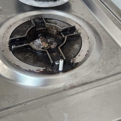 כיריים גז עם מבערים מלוכלכים וחלקי מתכת