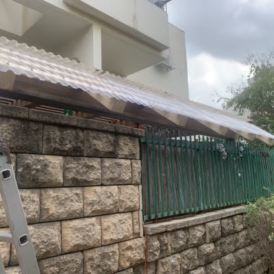 סולם ליד גדר עץ עם גג פלסטיק שקוף