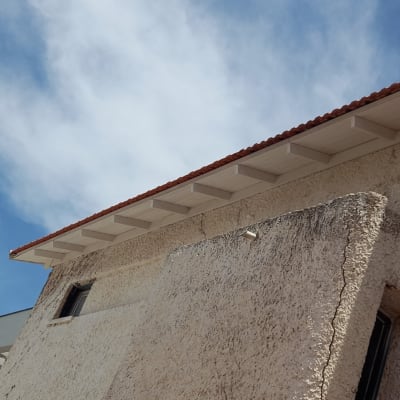 גג רעפים אדום עם תקרה לבנה מתחתיו