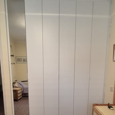 ארון לבן עם דלתות, שולחן עץ בצד