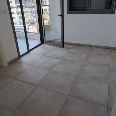 רצפה נקייה עם אריחים גדולים ליד דלת זכוכית