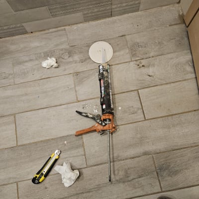 אקדח סיליקון וסכין יפנית על רצפה