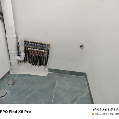 צנרת מים מותקנת על קיר עם אריחי רצפה חדשים