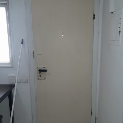 דלת לבנה עם ידית שחורה ומנעול