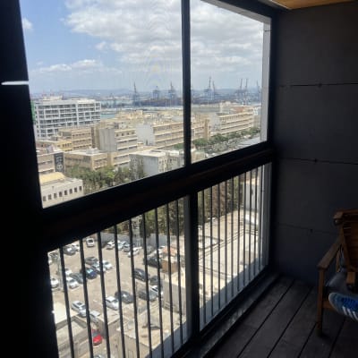 חלון אלומיניום עם נוף עירוני ונמל ברקע