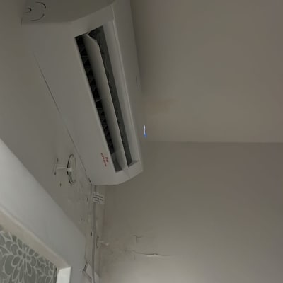 התקנת מזגן עילי מפוצל בצבע לבן על הקיר